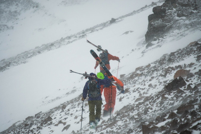 Lucy Higgins, Curtis Berklund and Austin Johnson shoulder thier skis for the wind buffeted scree fields on the way to La Chiminea Couloir in TK. [Photo] Jacob O'Connor